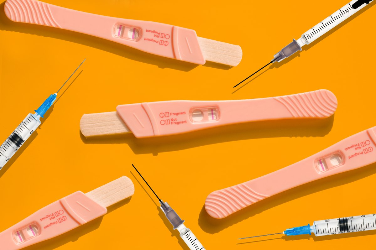 Pregnancy tests and syringes against a yellow background