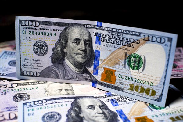 A $100 bill atop a pile of other bills