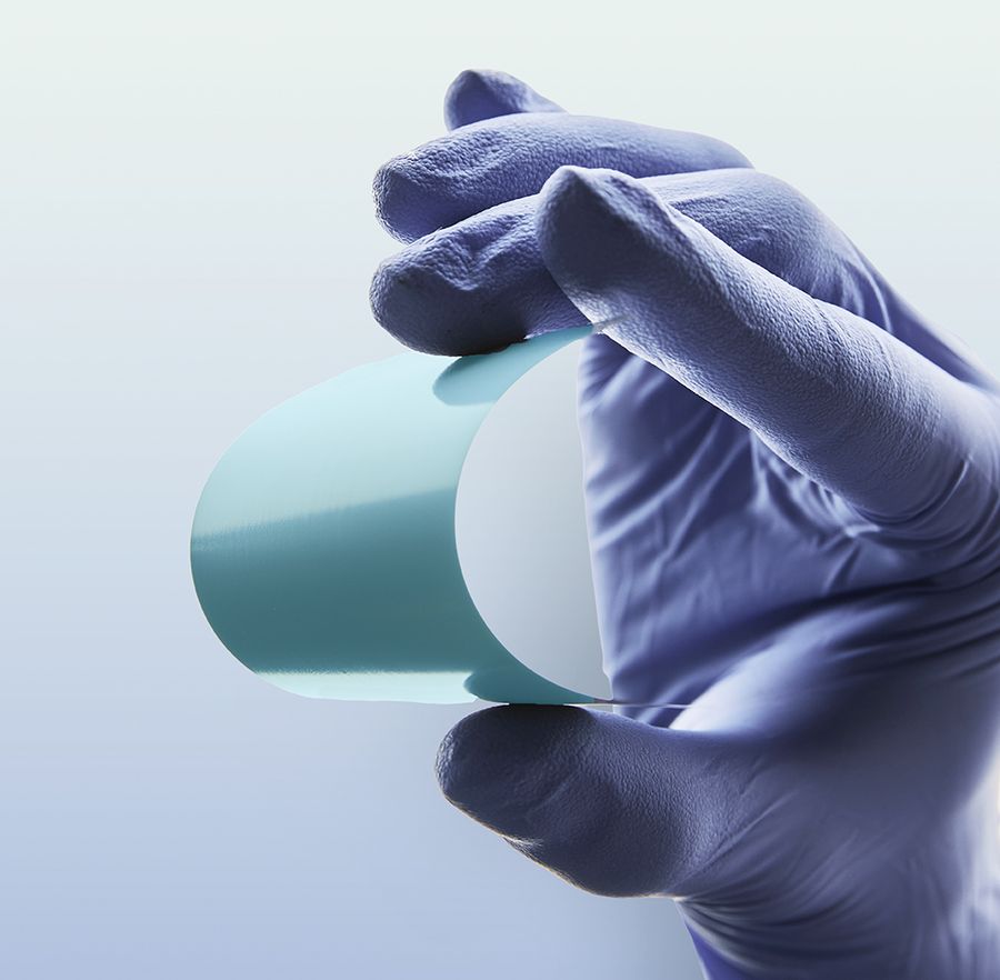 Close up of a sterile-gloved hand bending QuantumScape's thin, flexible ceramic separator. Image provided by QuantumScape.