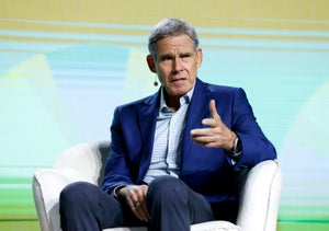 Eric Topol in a blue suit, sitting on an armchair and speaking to an audience.