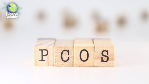 Wooden blocks with letters spell PCOS against a blurry white background
