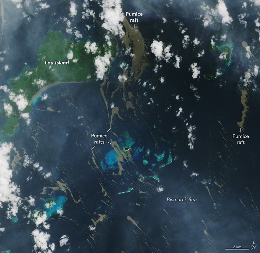 Satellite images show long streaks of brown against the deep blue sea and green of islands