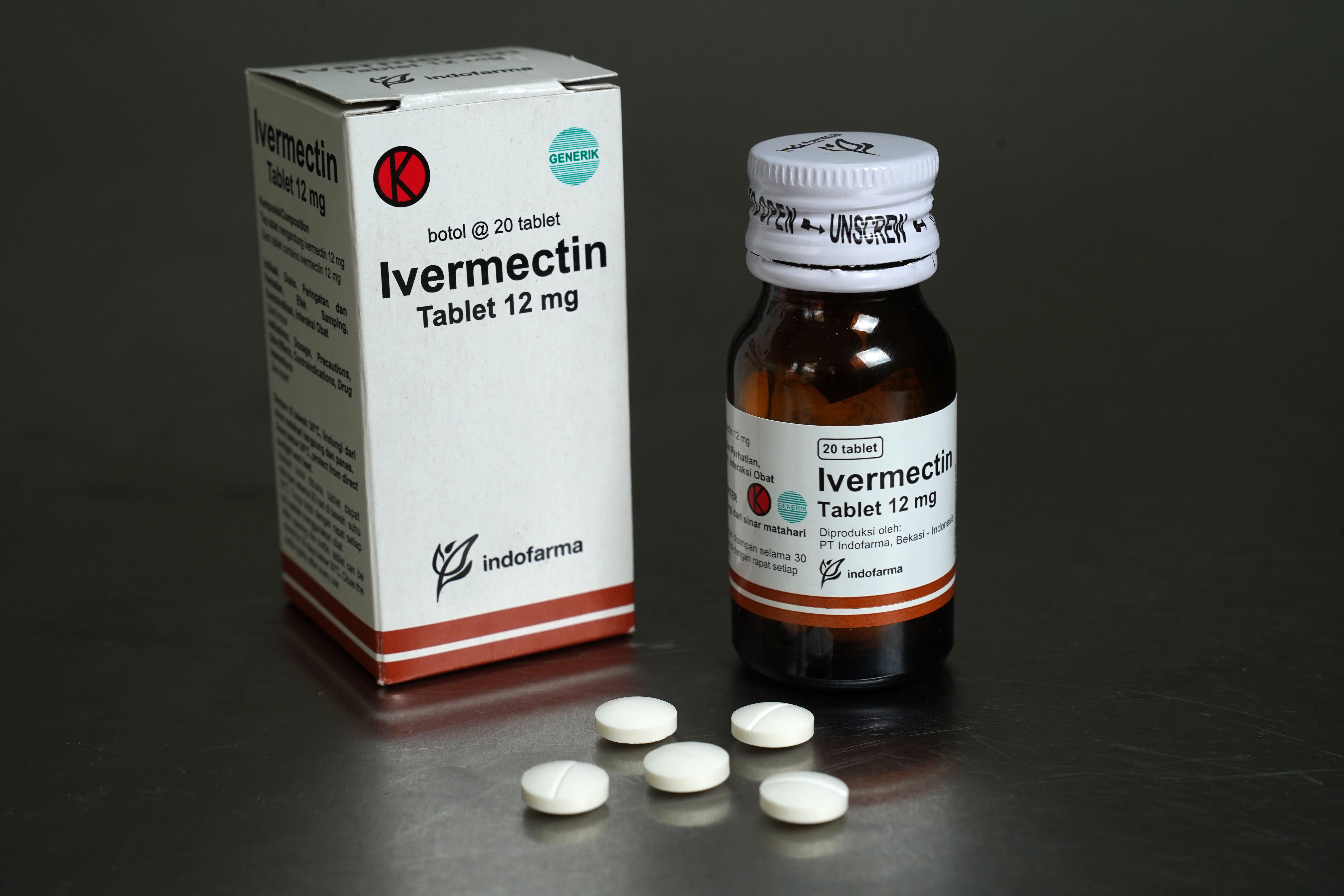 Ivermectin tablets arranged in front of a package and bottle