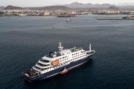 This aerial view shows health personnel boarding the cruise ship MV Hondius, while stationary off the port of Praia, the capital of Cape Verde, on May 6, 2026.