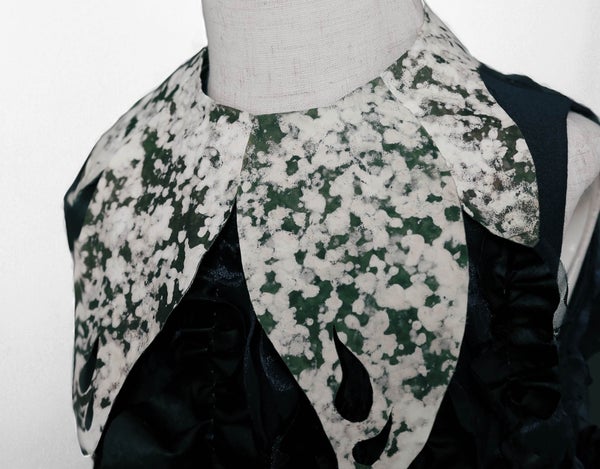 A greenish and achromatic splattered collar connected a garment made of fungus.