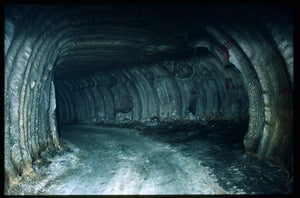 A dark tunnel through white, gray and brown material