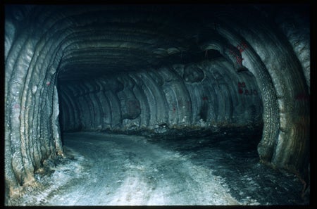 A dark tunnel through white, gray and brown material