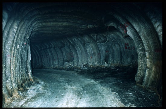 A dark tunnel through white, gray and brown material