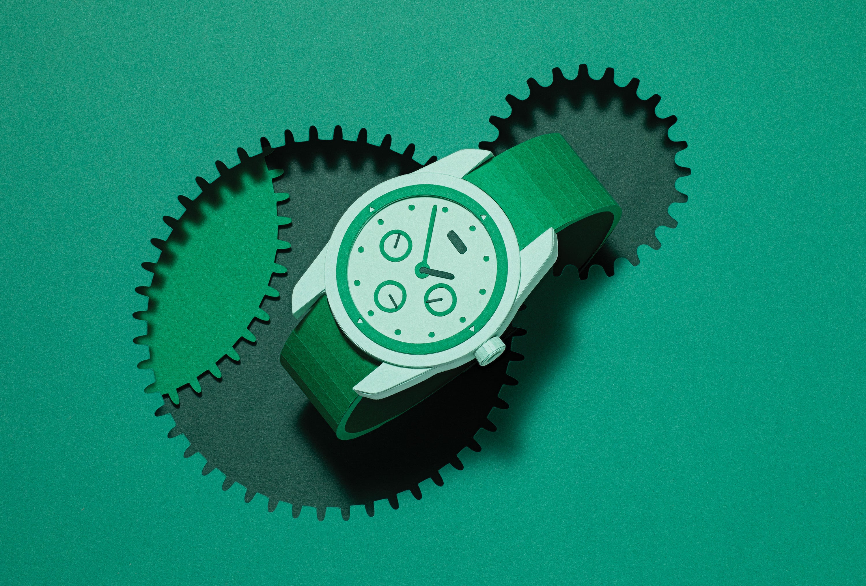 A dimensional watch inside a cutout of a toothed gear against a green background.