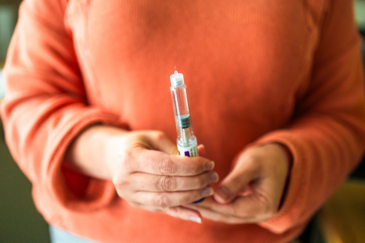 a woman hold a weight loss injection pen, preparing to administer is