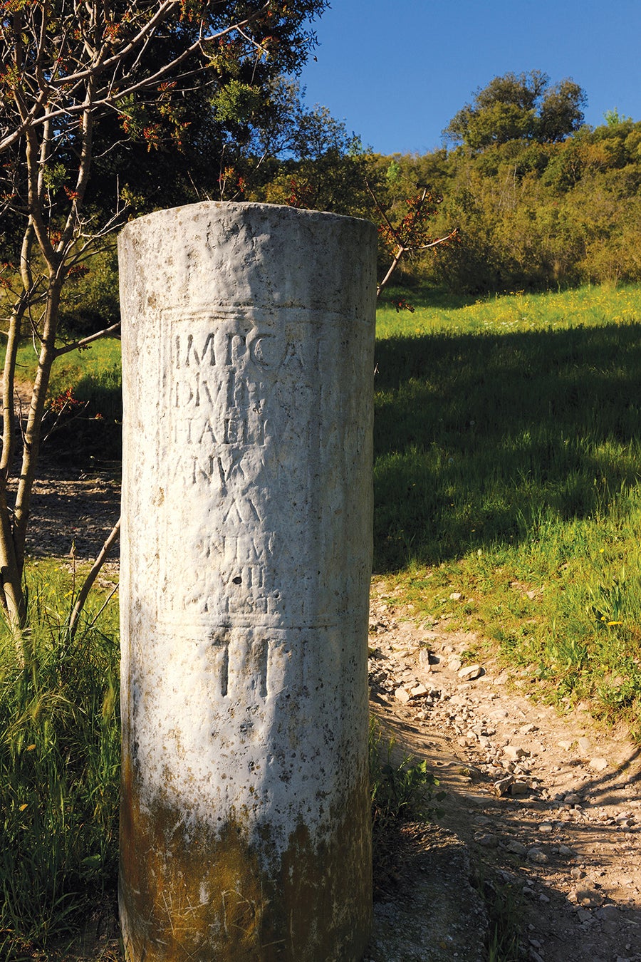 A stone cylinder bears an engraved inscription.