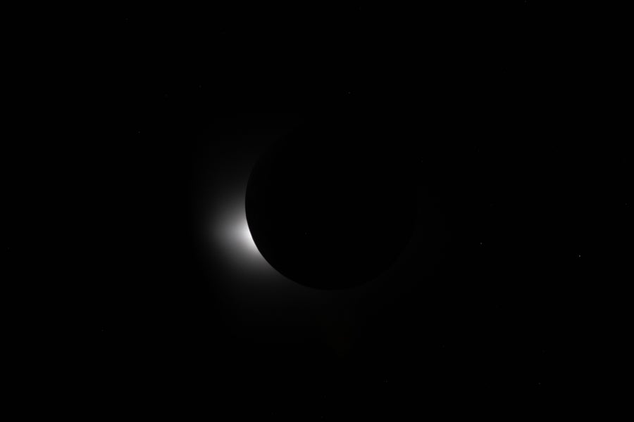 A mostly black image with a small big of light blocked by a black edge.