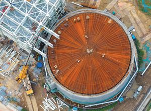 Daytime overhead view of the Guoxin Salt Cave Compressed Air Energy Storage project facility, a round structure with a rust-colored roof. Image provided by CFOTO/Future Publishing via Getty Images.