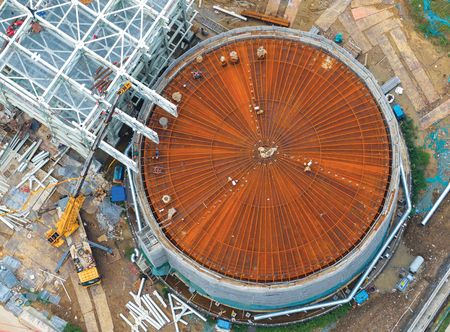 Daytime overhead view of the Guoxin Salt Cave Compressed Air Energy Storage project facility, a round structure with a rust-colored roof. Image provided by CFOTO/Future Publishing via Getty Images.