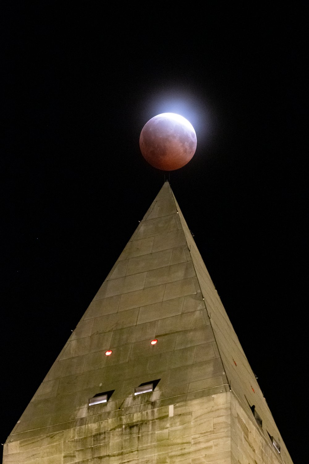 The moon at the tip of the Washington Monument.
