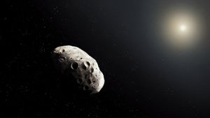 An asteroid drifts through deep space with the Sun in the distant background.