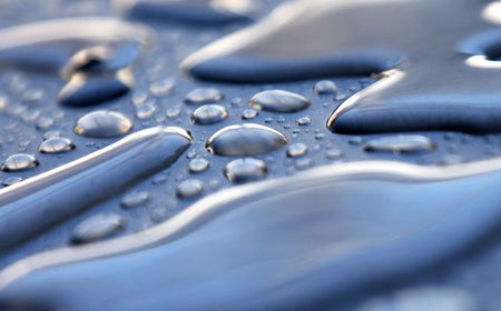 Drops of water beading on a metal surface