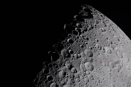 A view of the moon's surface in striking detail, full of craters.