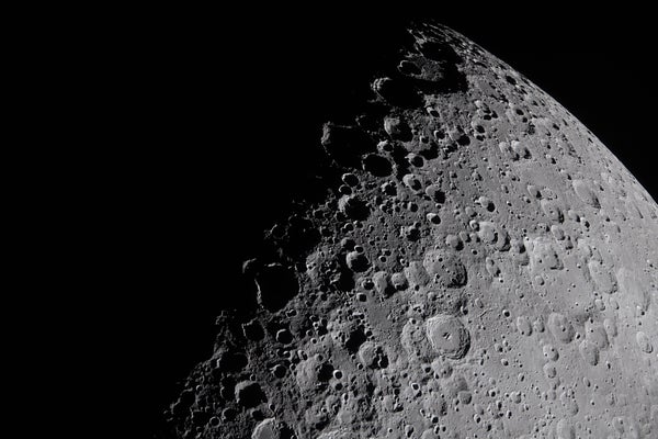 A view of the moon's surface in striking detail, full of craters.