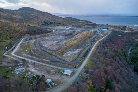 An aerial shot of the landfill in Ushuaia, Tierra del Fuego, Argentina, overlooking the sea.