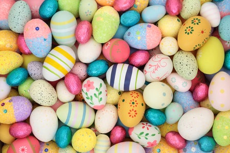Easter egg background with large collection of decorated and foil wrapped eggs.