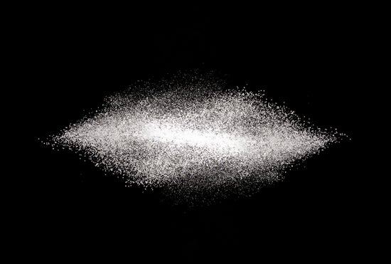 A scattering of table sugar against a black background.
