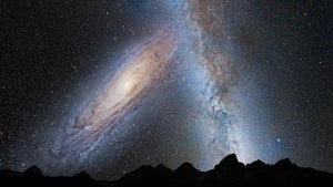 A starry dark sky dominated by a collision between two spiral galaxies.
