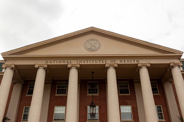 A view of the main historical building of the National Institutes of Health at the agency’s campus in Bethesda, Md. The U.S. Public Health Service Commissioned Corps seal is seen at the top of the building.