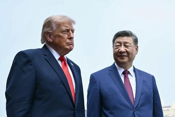 U.S. president Donald Trump and Chinese president Xi Jinping stand against a clear sky in Beijing.