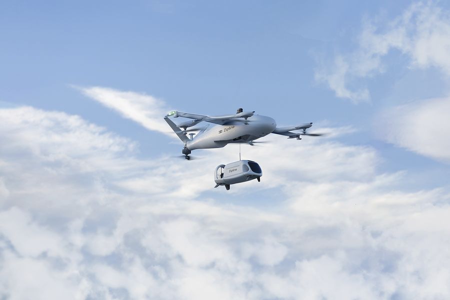 Aerial photo provided by Zipline of it's drone plane carrying the land drone for deliveries.