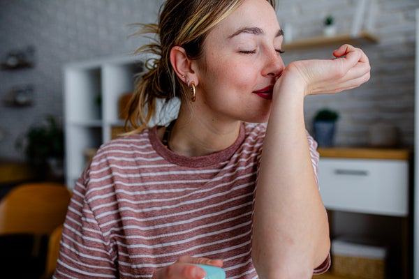 Young woman smelling her wrists