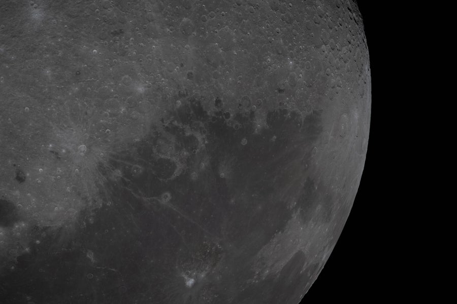 A view of the lunar surface with a large patch of dark mare terrain visible.