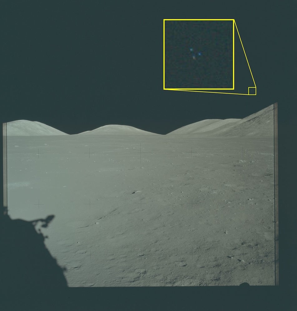 Apollo 17 photograph showing three small bright dots in a triangular pattern against the dark lunar sky, with the gray lunar surface in the foreground.