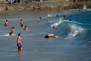 People cool off in the Pacific Ocean at Crescent Bay Beach in Laguna Beach, Calif., on March 20, the first day of spring, during a record-setting heat wave that blanketed southern California.