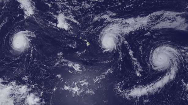A satellite view of three hurricanes surrounding the Hawaiian islands.