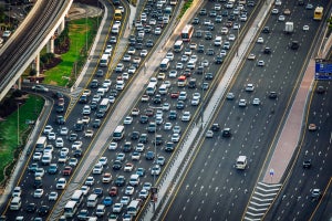 A high-angle perspective showing busy vehicle traffic on a multi-lane highway going in both directions.