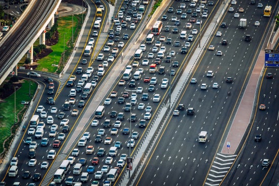 A high-angle perspective showing busy vehicle traffic on a multi-lane highway going in both directions.