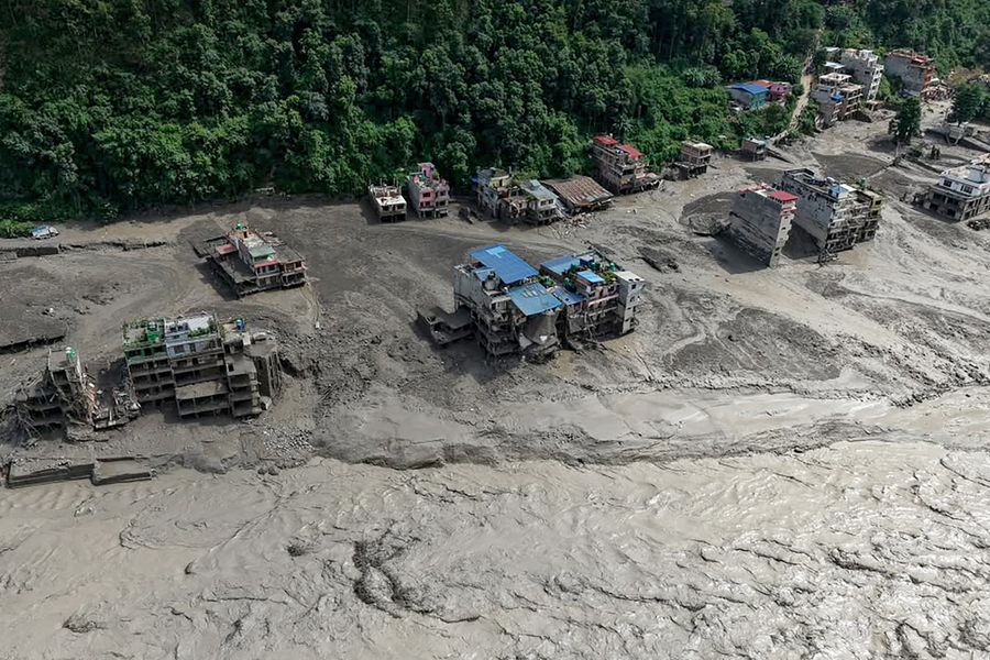Partially submerged houses in muddy water.