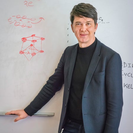Gerd Ceder standing in front of a white board.