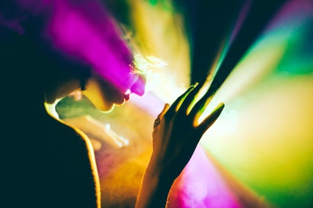 A futuristic woman exploring a bright and colorful outer space that evokes a psychedelic trip.