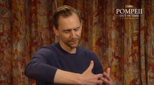 A man makes a hugging gesture intertwining his fingers together