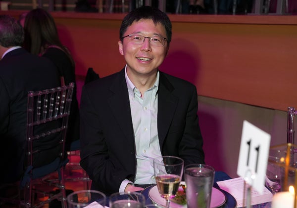 Feng Zhang attends the New York Stem Cell Foundation. He is sitting at a table in a suit.