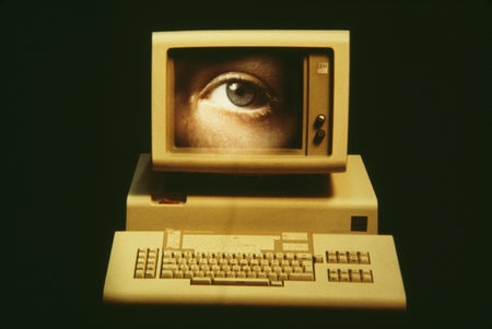 A close-up of a human eye on the screen of a vintage computer