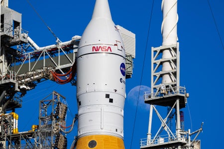 The moon is seen shining next to the SLS (Space Launch System) and Orion spacecraft atop the mobile launcher on January 28, 2026, at Launch Pad 39B at NASA’s Kennedy Space Center in Florida.