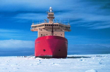Bright red icebreaker ship sails through icy Antarctic waters
