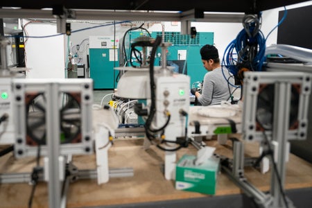 Person in grey T-shirt and black cap sitting in the equipment area of a Carbon Capture Company.