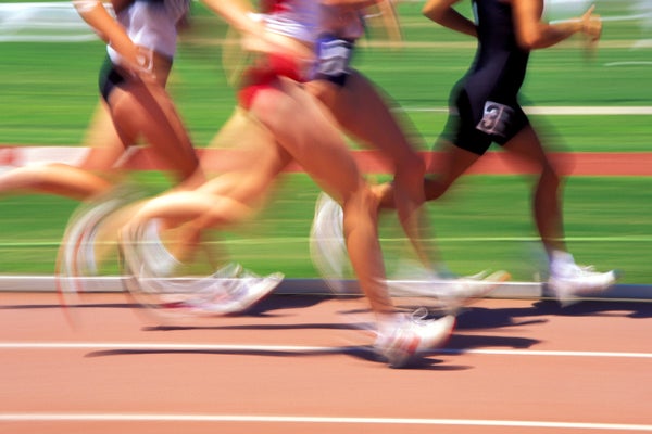 Athletes running in a race on a track with motion blur from the running movement