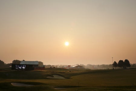 A hazy sun over a farm landscape