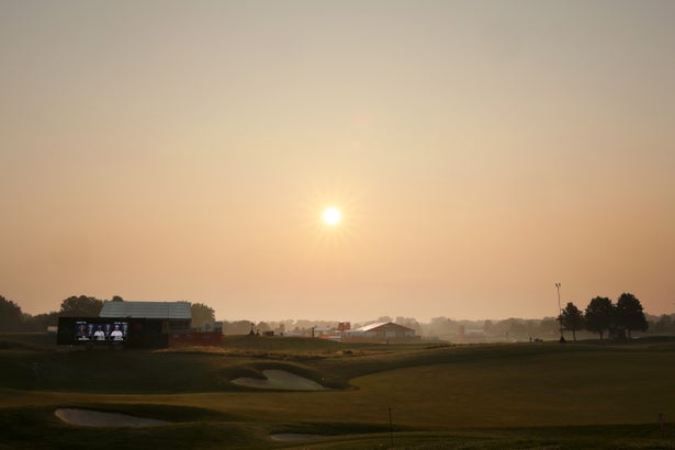 A hazy sun over a farm landscape