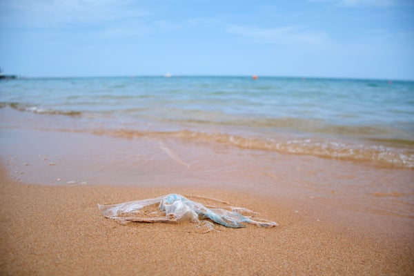 Deixado para trás lixo de sacola de plástico na praia de areia